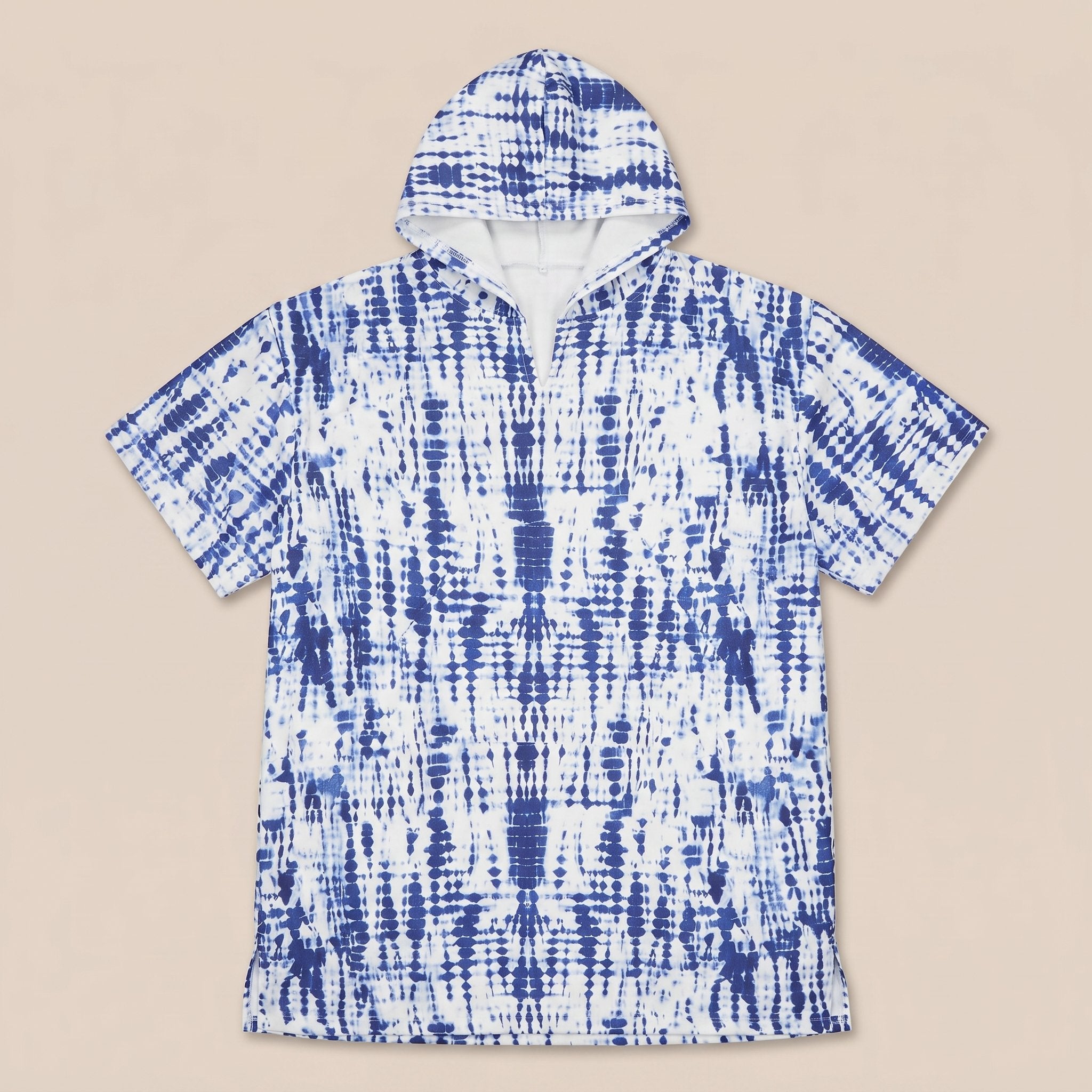 Poncho serviette a capuche motif tie-dye bleu, présenté à plat sur un fond uni clair.