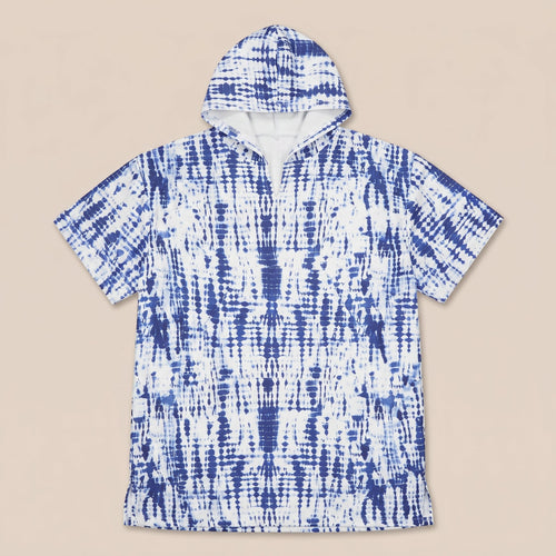Poncho serviette a capuche motif tie-dye bleu, présenté à plat sur un fond uni clair.