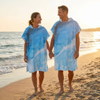 Poncho serviette a capuche motif Vague bleue, porte par un couple marchant main dans la main.