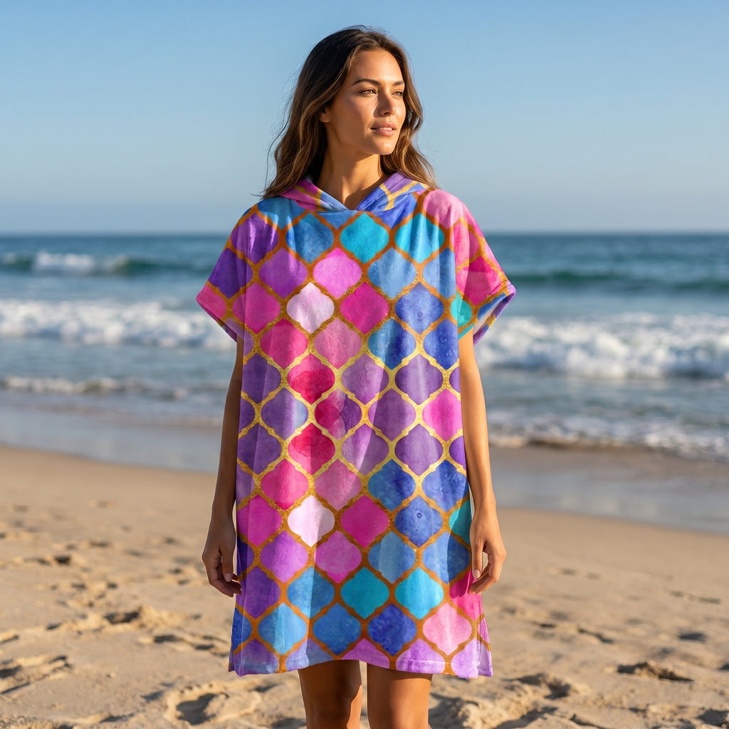 Poncho serviette à capuche motif carreaux marocains, porté par une femme sur la plage, vue de face.