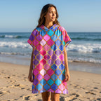 Poncho serviette à capuche motif carreaux marocains, porté par une femme sur la plage, vue de face.