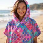 Poncho serviette à capuche motif carreaux marocains, porté par une femme souriante, cadrage serré sur le buste.