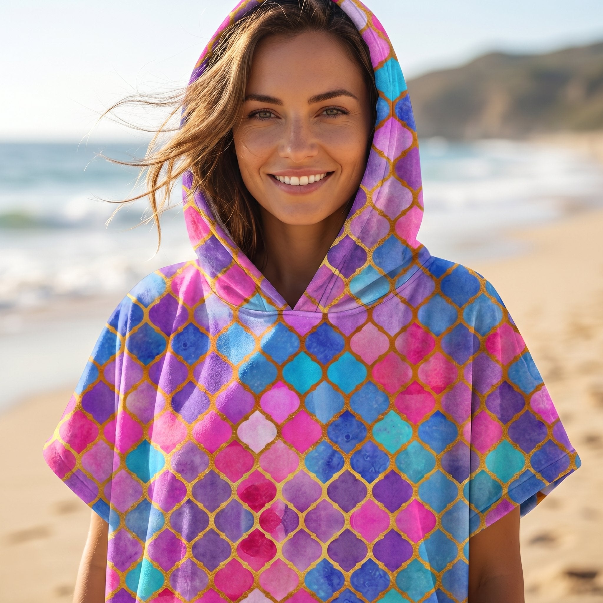 Poncho serviette à capuche motif carreaux marocains, porté par une femme souriante, cadrage serré sur le buste.
