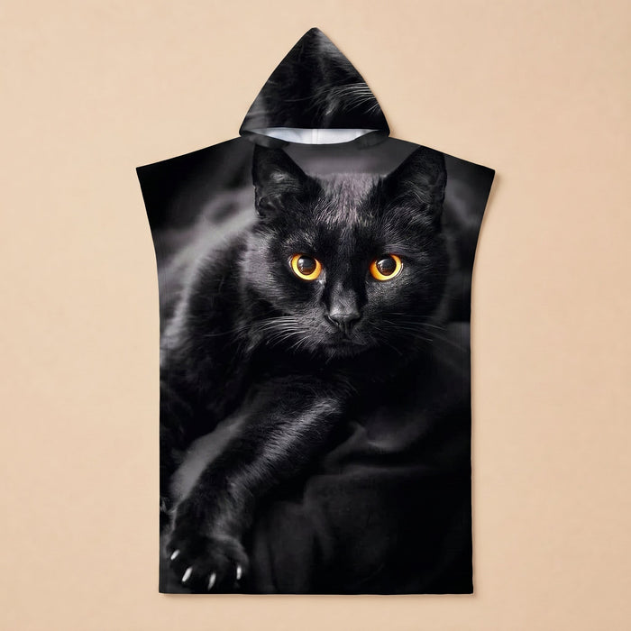 Poncho serviette à capuche motif chat noir, posé à plat, montrant le motif en gros plan.
