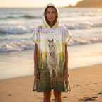 Poncho serviette à capuche motif chevaux au couchant, porté par une femme de face sur la plage.