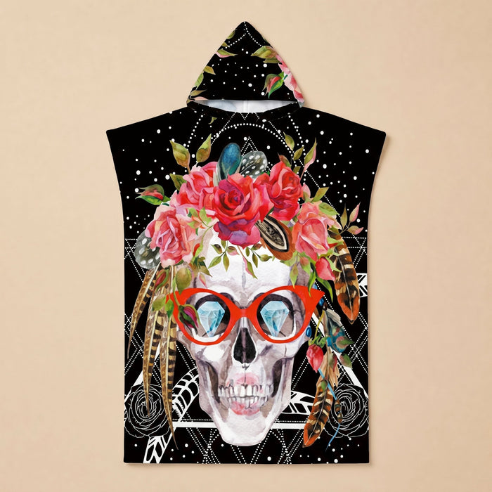 Poncho serviette à capuche motif crâne à lunettes, présenté à plat sur un fond uni.