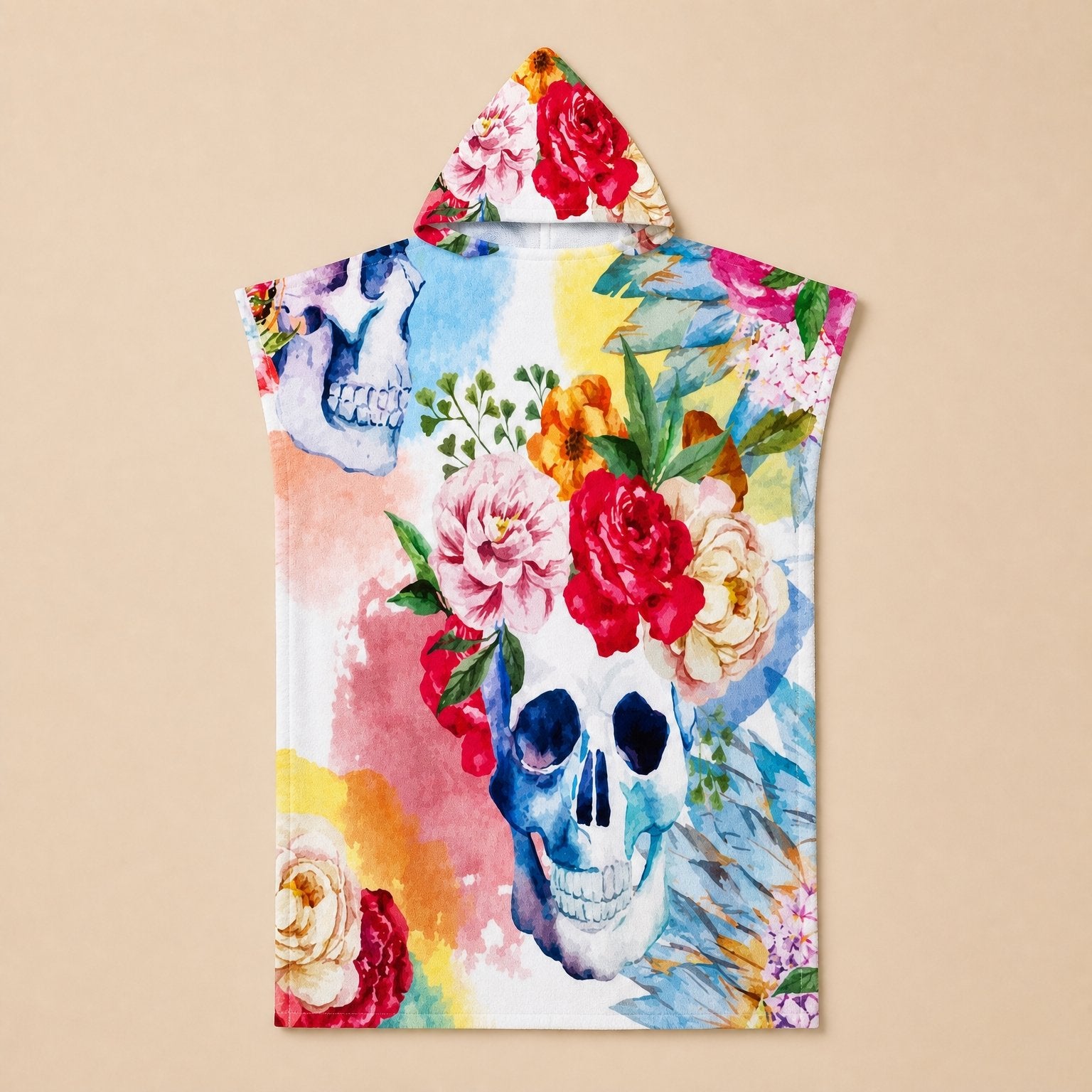 Poncho serviette à capuche motif crâne fleuri, présenté à plat sur un fond uni clair.