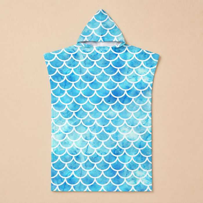 Poncho serviette à capuche motif écailles bleu ciel, présenté à plat sur un fond uni.