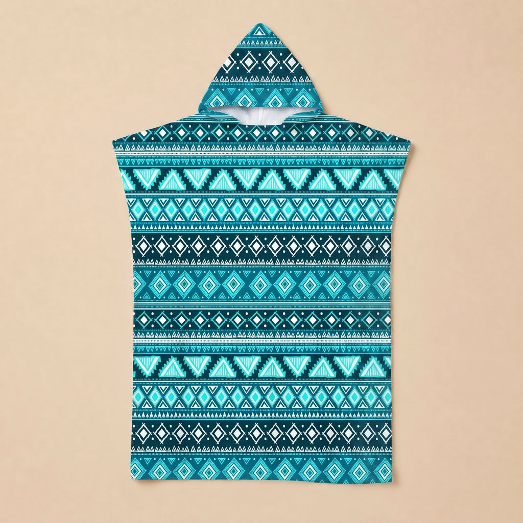Poncho serviette à capuche motif aztèque bleu posé à plat sur un fond beige uni.