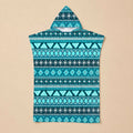 Poncho serviette à capuche motif aztèque bleu posé à plat sur un fond beige uni.