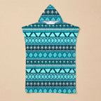 Poncho serviette à capuche motif aztèque bleu posé à plat sur un fond beige uni.
