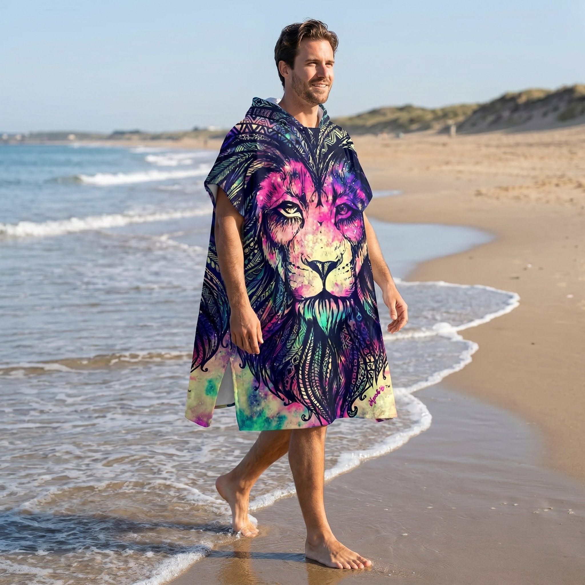 Poncho serviette à capuche motif lion psychédélique, porté par un homme marchant sur la plage.