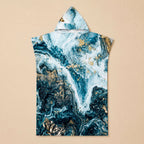 Poncho serviette à capuche motif marbré bleu et or, présenté à plat sur un fond uni clair.