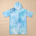 Poncho serviette à capuche motif requin-baleine, posé à plat et entièrement zippé sur un fond uni.