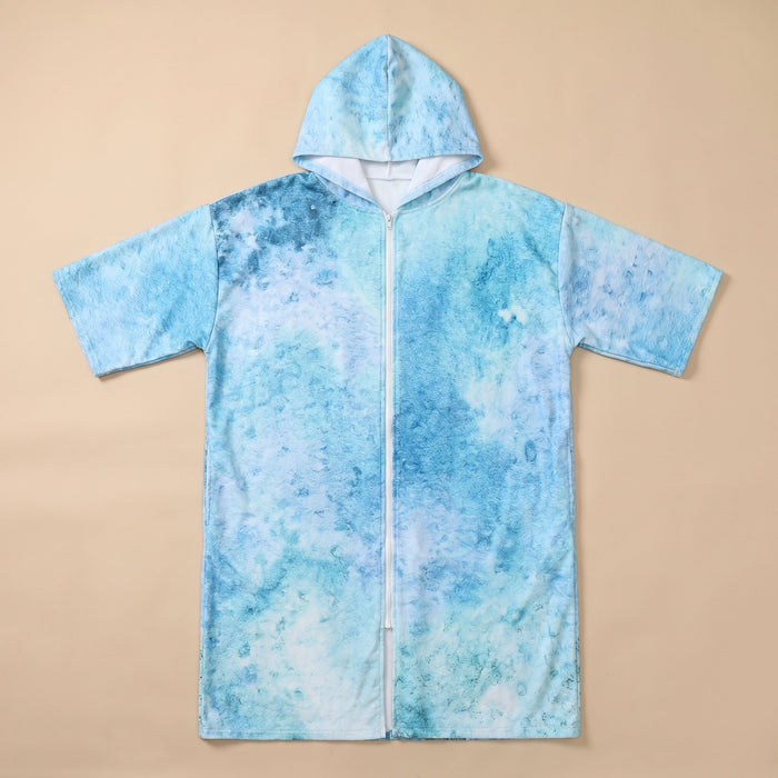 Poncho serviette à capuche motif requin-baleine, posé à plat et entièrement zippé sur un fond uni.