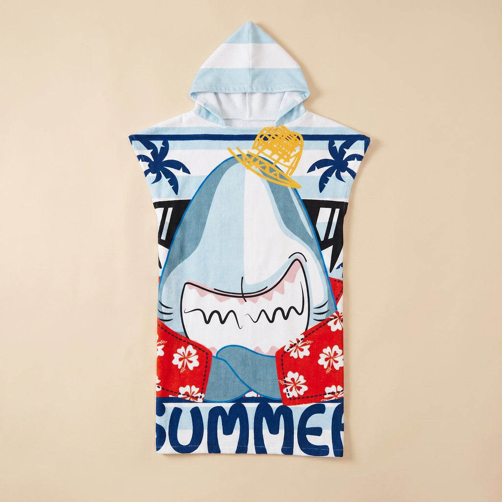 Poncho serviette à capuche motif requin hawaïen, posé à plat sur un fond uni beige.
