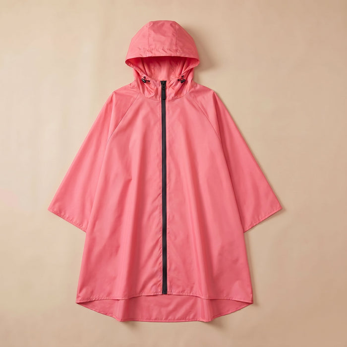 Poncho de pluie à capuche corail uni, posé à plat sur un fond clair et uni.