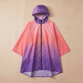 Poncho de pluie à capuche dégradé corail et violet, présenté de face et posé à plat sur un fond uni.