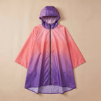 Poncho de pluie à capuche dégradé corail et violet, présenté de face et posé à plat sur un fond uni.