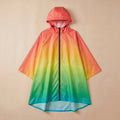 Poncho de pluie à capuche dégradé tropical, présenté de face et à plat sur un fond beige uni.