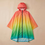 Poncho de pluie à capuche dégradé tropical, présenté de face et à plat sur un fond beige uni.