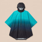 Poncho de pluie à capuche dégradé turquoise et nuit, présenté à plat sur un fond uni.