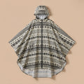 Poncho de pluie à capuche motif ethnique noir et blanc, présenté à plat sur un fond uni.