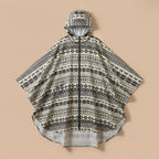 Poncho de pluie à capuche motif ethnique noir et blanc, présenté à plat sur un fond uni.