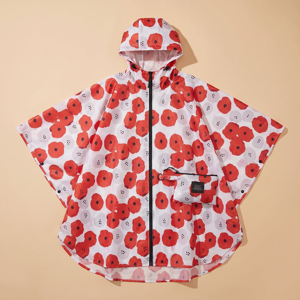 Poncho de pluie à capuche femme à fleurs posé à plat, motif floral rouge et blanc, avec sa pochette de rangement assortie
