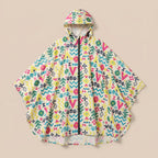 Poncho de pluie à capuche motifs multicolores, posé à plat, vue de face sur fond uni.