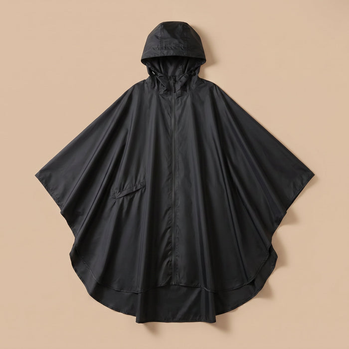 Poncho de pluie à capuche noir uni, présenté à plat sur un fond beige clair.