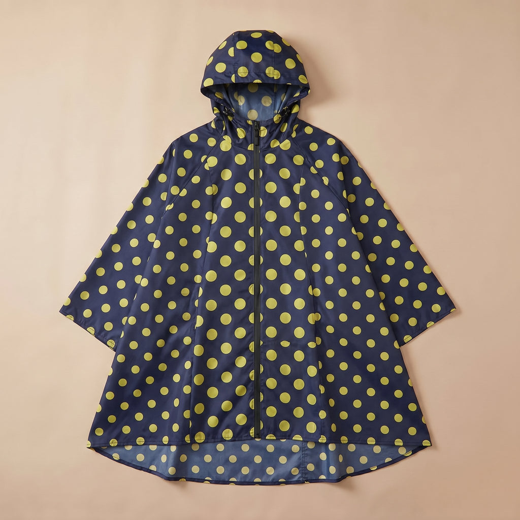 Poncho de pluie à capuche motif Pois jaunes, posé à plat sur un fond uni et clair.