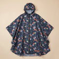 Poncho de pluie à capuche motif roses marine, posé à plat sur un fond uni beige.