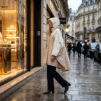 Poncho de pluie à capuche sable uni, porté par une femme de profil marchant le long d'une vitrine.