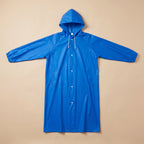 Poncho de pluie long bleu roi, présenté à plat sur un fond uni, vue de face.