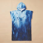Poncho serviette à capuche motif raie manta, posé à plat sur un fond uni clair.