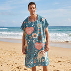 Poncho serviette a capuche motif girafes d'été porté par un homme debout sur le sable de la plage.