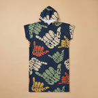 Poncho serviette à capuche motif shakas colorés, posé à plat sur un fond uni beige.