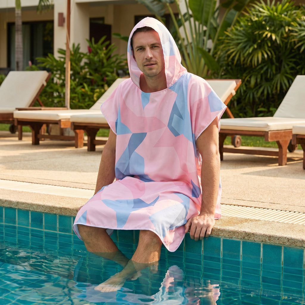 Poncho de surf à capuche · Triangles, porté par un homme assis au bord d'une piscine, les pieds dans l'eau.