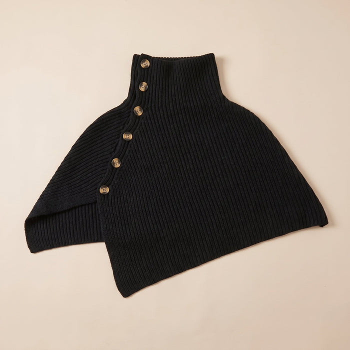 Poncho en laine femme noir, avec col montant et boutons, posé à plat sur un fond clair.