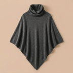 Poncho en laine femme col roulé gris, présenté à plat sur un fond uni clair.