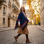 Poncho femme chaud à motif aztèque et franges bleu marine, porté par une femme de profil marchant sur des pavés