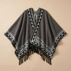 Poncho femme chaud à motif aztèque et franges gris foncé, avec motifs géométriques noirs et gris clair, posé à plat