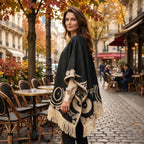 Poncho femme ethnique noir et crème à franges porté de profil par une femme, montrant les motifs latéraux et les franges