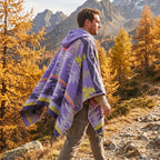 Poncho mexicain homme à capuche, coloris violet et jaune, porté de profil par un homme marchant en montagne