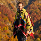 Poncho mexicain homme à capuche, coloris jaune, rouge et noir, porté de face par un homme souriant