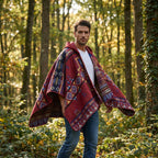 Poncho à capuche pour homme, coloris rouge avec motifs colorés, porté de trois quarts dans une forêt
