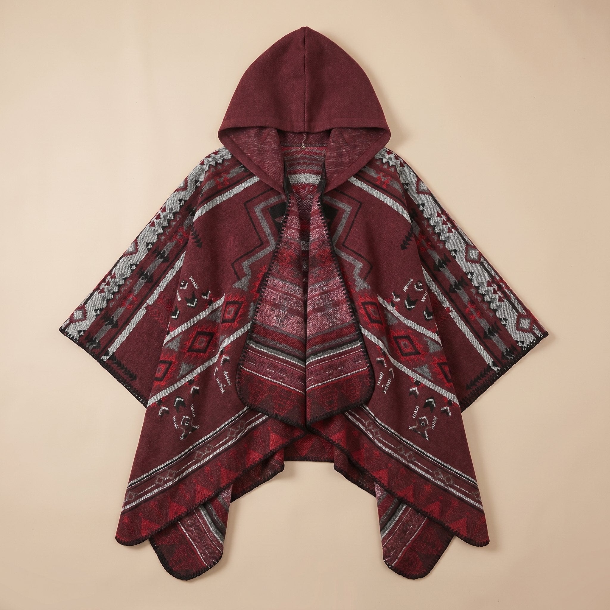 Poncho péruvien homme à capuche bordeaux avec motifs géométriques gris, noirs et rouges, posé à plat