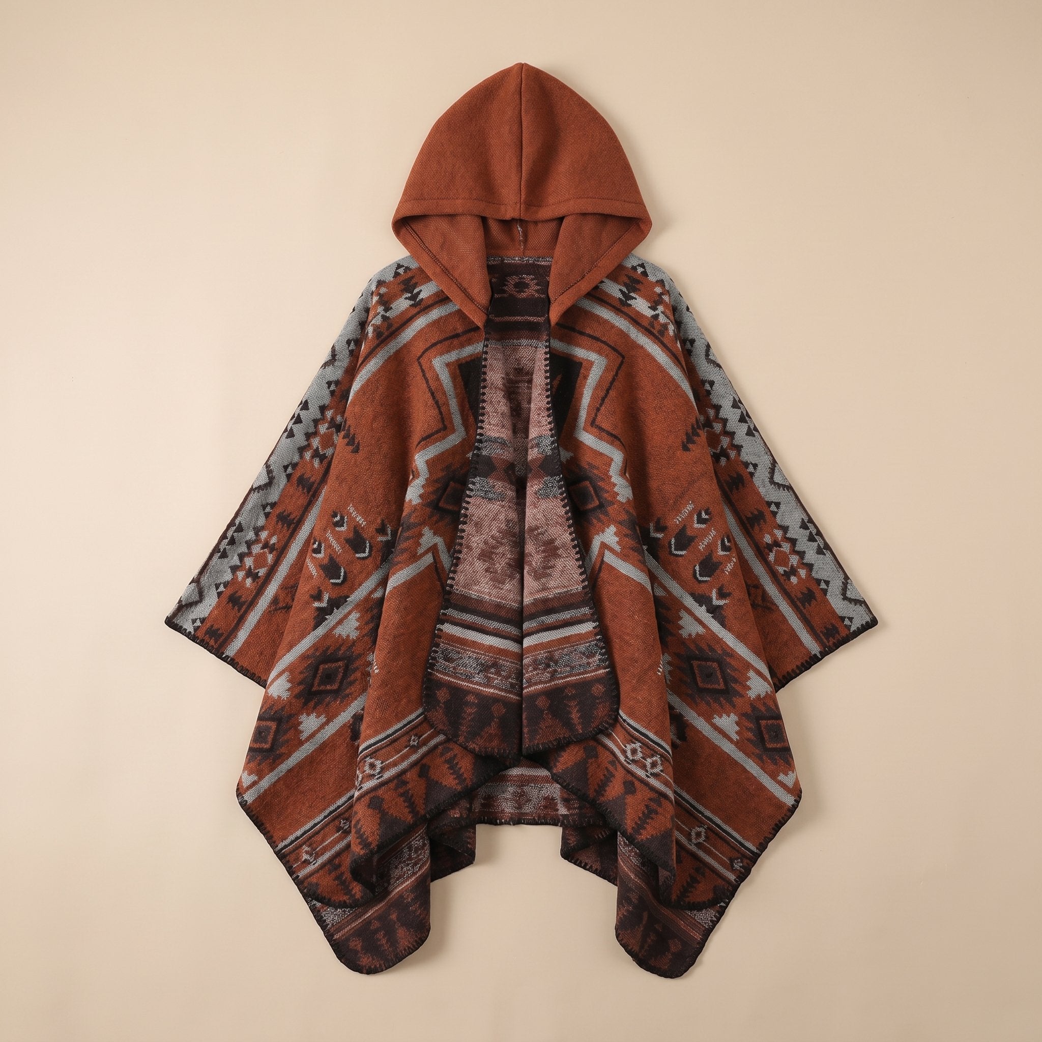 Poncho péruvien homme à capuche couleur rouille avec motifs géométriques gris et noirs, étalé