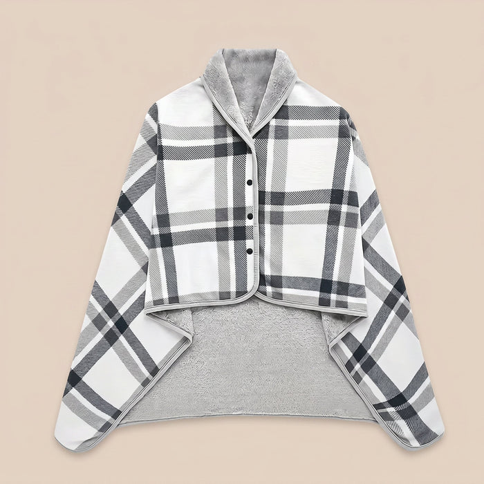 Poncho plaid à carreaux blancs présenté à plat sur un fond uni clair, montrant son motif et sa doublure.